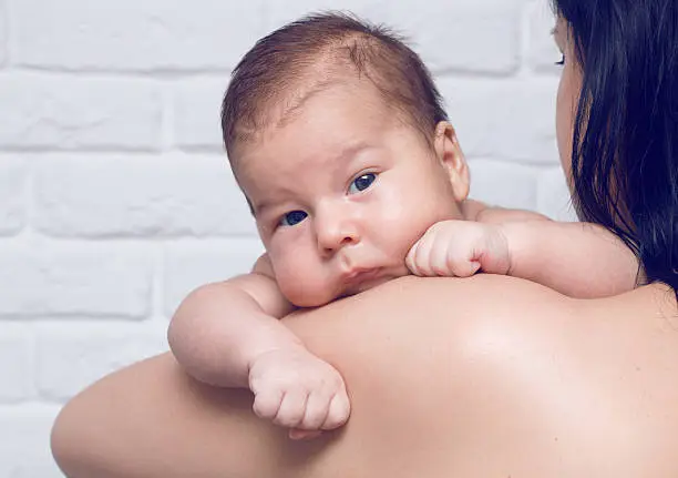 Little baby with his mother looking into camera, maternity concept