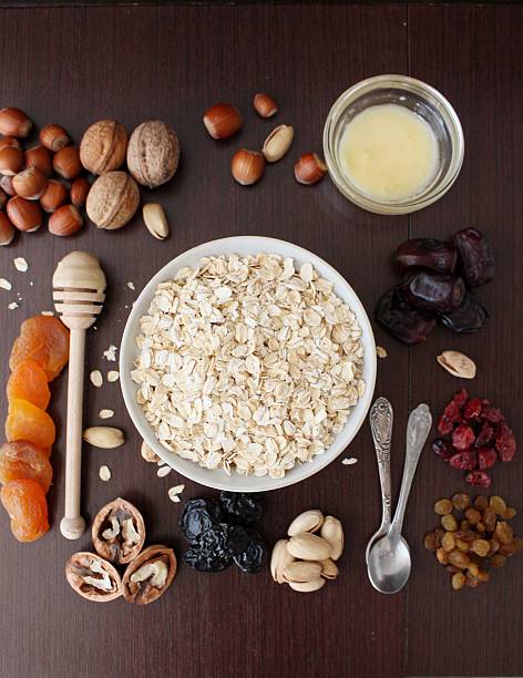 Granola bars ingredients on wood background, top view