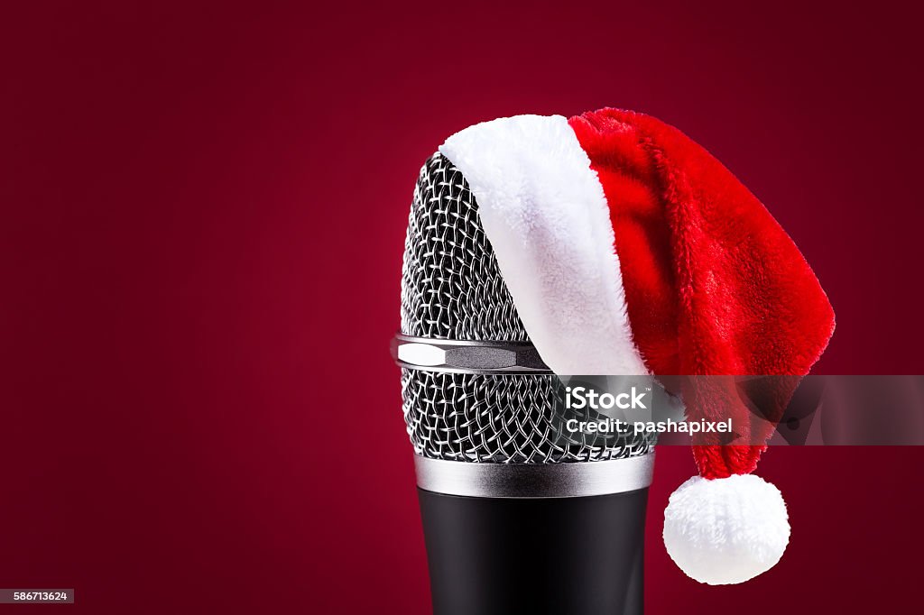 Wireless microphone with santa hat on it Wireless microphone with santa hat on it closeup on red background Christmas Stock Photo