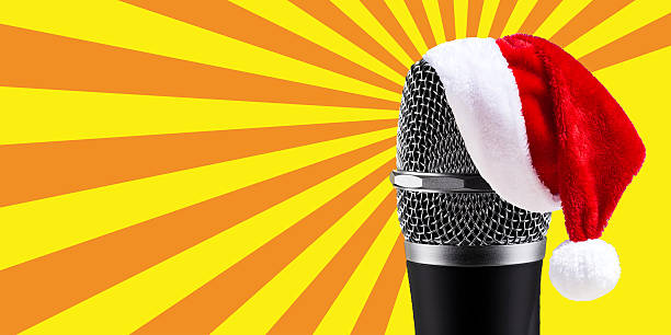 istock Santa Claus Hat on wireless microphone on yellow stripes backgro 586715088