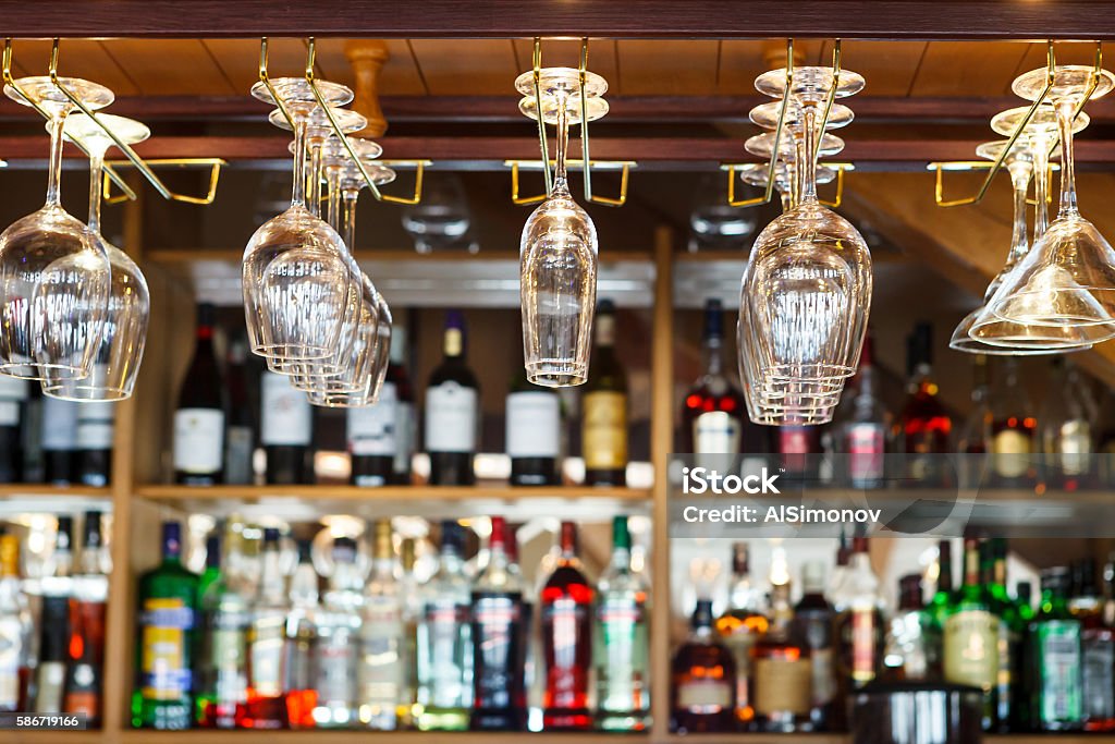 different glasses hanging over the bar. Soft focus. different glasses hanging over the bar. Soft focus. selective focus Bar - Drink Establishment Stock Photo