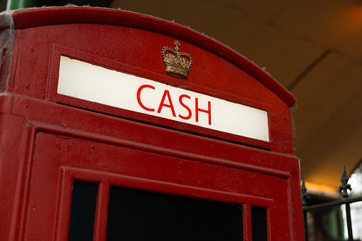 Cash on a british red phone booth.