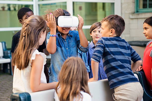 istock Group of elementary school kids experiencing virtual reality glasses. 586726236