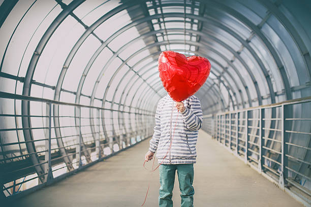 istock boy in dark tunnel with red heart in the hands 586726294