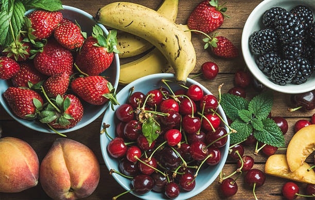 istock Summer fresh fruit and berry variety over wooden backdrop 586726450