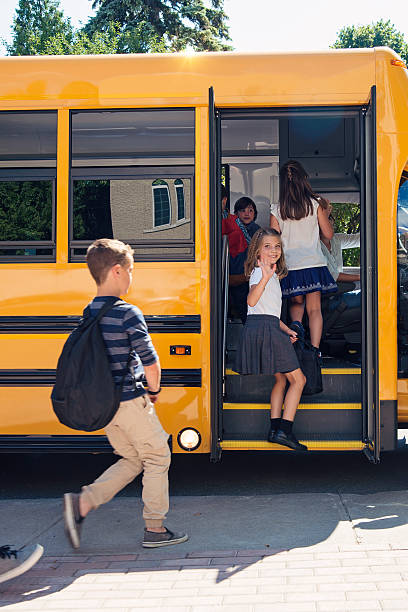 istock Group of elementary school kids getting in yellow school bus. 586727142