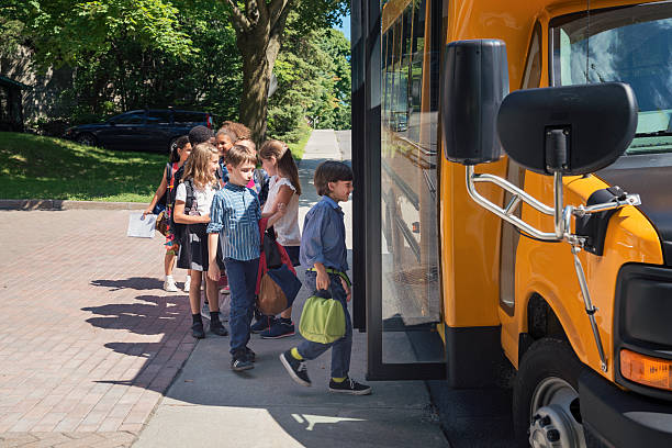 istock Group of elementary school kids getting in yellow school bus. 586727236
