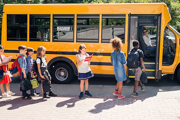 istock Group of elementary school kids getting in yellow school bus. 586727638