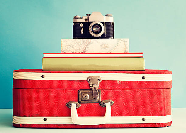 istock Vintage camera over books and suitcase 586729854