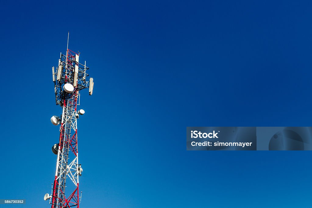 Cell phone antenna tower with blue sky background Communications Tower Stock Photo