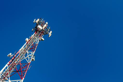 Cell phone antenna tower with blue sky background