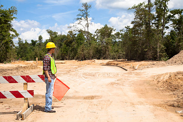 istock Construction worker, signalman directs traffic at job site. 586731194