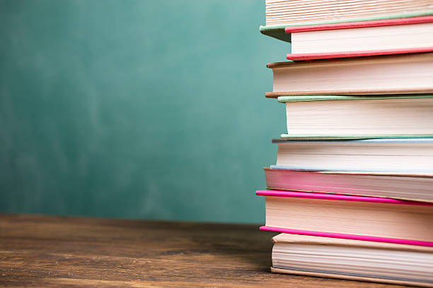 istock Textbooks stacked on school desk with chalkboard background. 586732540
