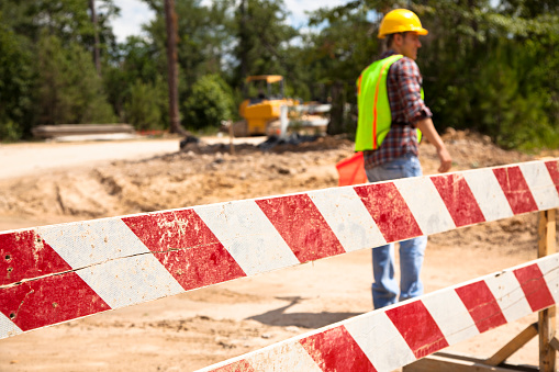 Construction worker, flagman directs traffic at job site.