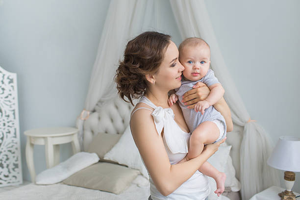 istock Young mother holds her infant and look at him 586736248