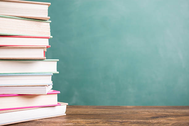 istock Textbooks stacked on school desk with chalkboard background. 586737292