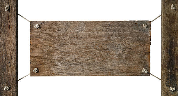 istock Old weathered wood signboard hanging from posts by old rope. 586740230