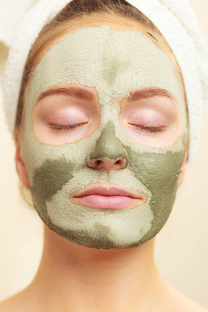 istock Woman face with green clay mud mask 586741166