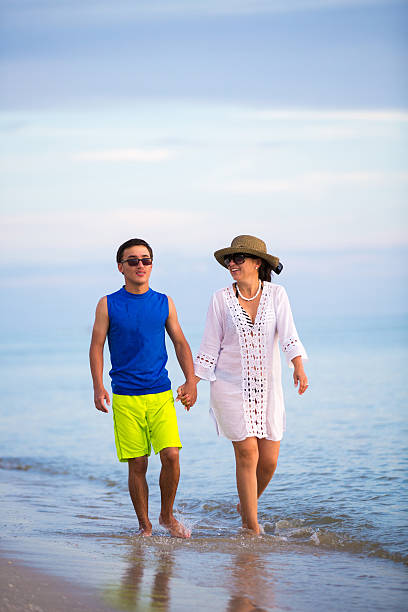 istock Mother and son walking on the beach 586741918
