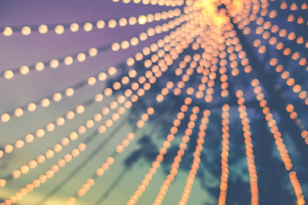 blurred background of  string light bulb  hanging for decorative exterior night party and blue sky background