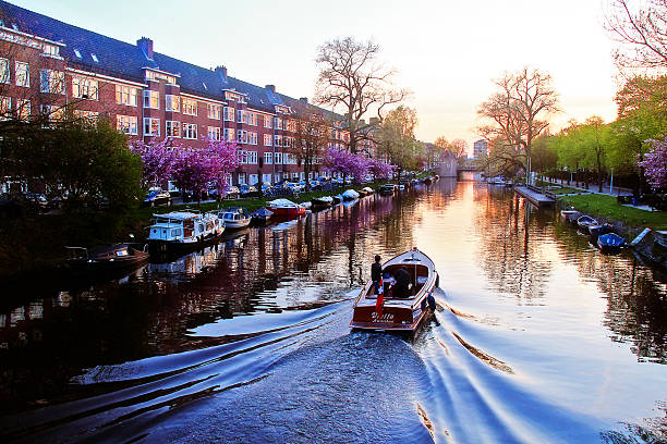 Amsterdam, Netherlands - May 04, 2016 - Evening scene of Amsterdam with speedboat running on river in resident area.