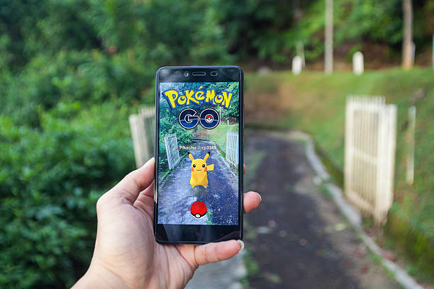 homem jogando pokemon go com fundo desfocado - brand name game - fotografias e filmes do acervo