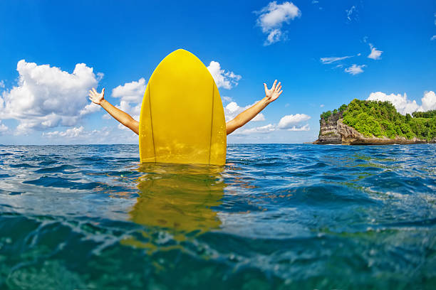 bonne fille surfeuse assise sur une planche de surf jaune dans l’océan - surfing men hawaii islands wave photos et images de collection