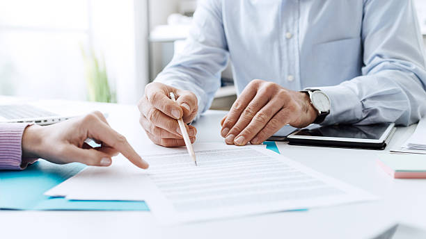 Business people negotiating a contract Business people negotiating a contract, they are pointing on a document and discussing together insurance agent photos stock pictures, royalty-free photos & images