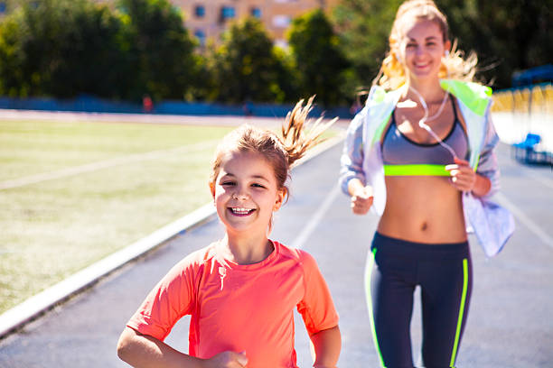istock Mother and little daughter are doing exercise in the stadium 586919776