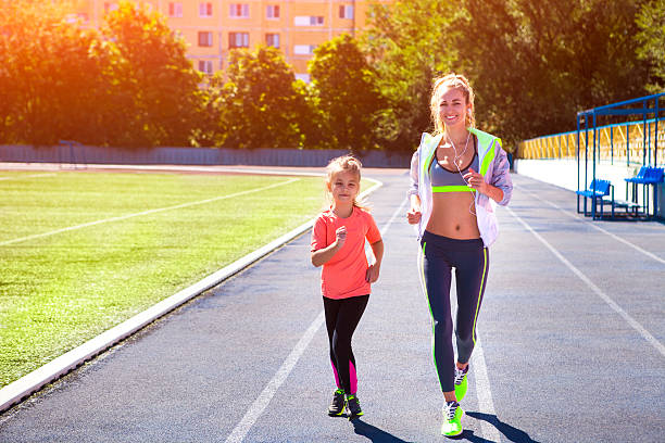 madre e hija pequeña hacen ejercicio en el estadio - track and field athlete women vitality speed fotografías e imágenes de stock