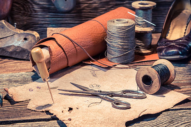 istock Closeup of shoemaker workshop with threads and leather 586919938
