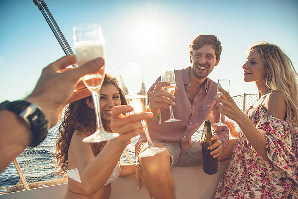 Friends summer vacation: party on a sailing yacht Friends summer vacation: party on a sailing yacht drinks on the deck stock pictures, royalty-free photos & images