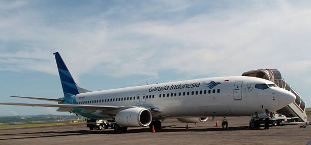 aereo garuda indonesia parcheggiato all'aeroporto di bali indonesia - garuda foto e immagini stock