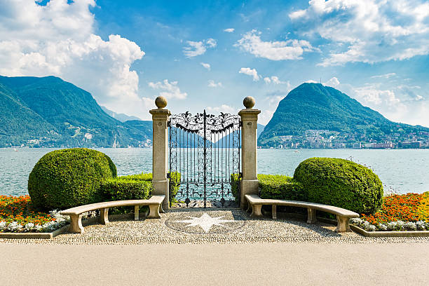 Lake Lugano from city park Lugano city on Lake Lugano in the Swiss canton of Ticino, Switzerland.  It is located at the foot of the Swiss Alps. This picture shows Lugano city from city park with lake and mountains. lugano stock pictures, royalty-free photos & images