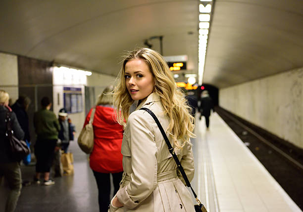 istock Blonde Swedish woman walking along commuter subway train platform 586930096