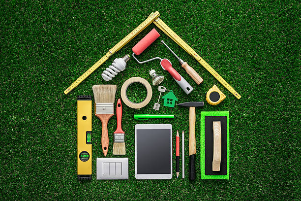 Home renovation and DIY Home renovation, remodeling and DIY concept, work tools and tablet composing a house shape on the grass repairman photos stock pictures, royalty-free photos & images