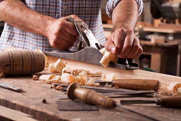 carpenter working with plane on wooden background stock photo