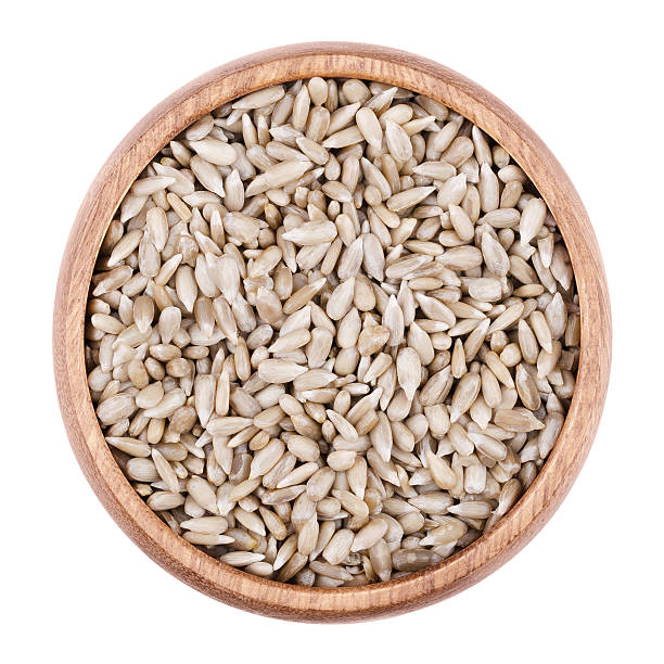istock Sunflower seeds in a bowl on white background 586933858