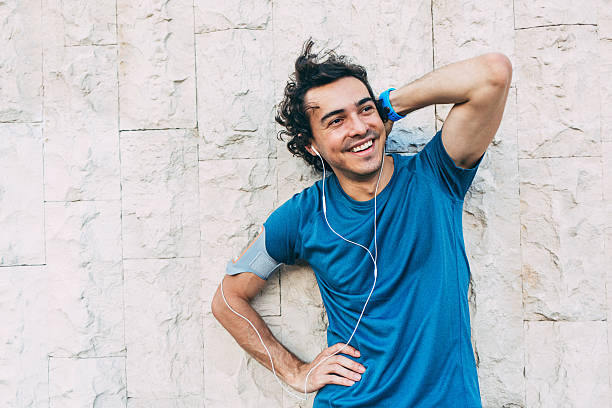 istock Smiling sportsman standing to a stone wall 586934266