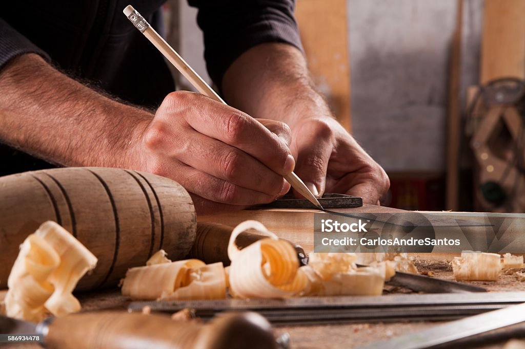 hand of a carpenter taking measurement of a wooden plank Carpenter Stock Photo