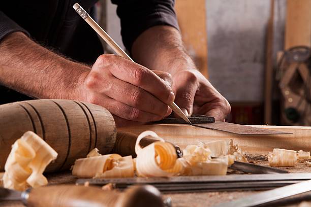 hand of a carpenter taking measurement of a wooden plank - carpenters pencil imagens e fotografias de stock