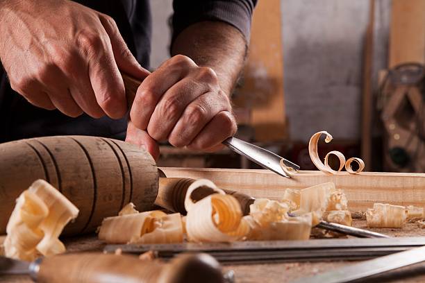 Hands of craftsman carve with a gouge Hands of craftsman carve with a gouge in the hands on the workbench in carpentry carving craft activity stock pictures, royalty-free photos & images