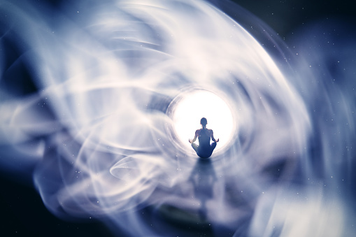 A conceptual image of a woman meditating in a mystical light.