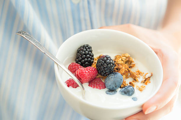 istock Female holding bowl with yogurt glanola and berries 586936496