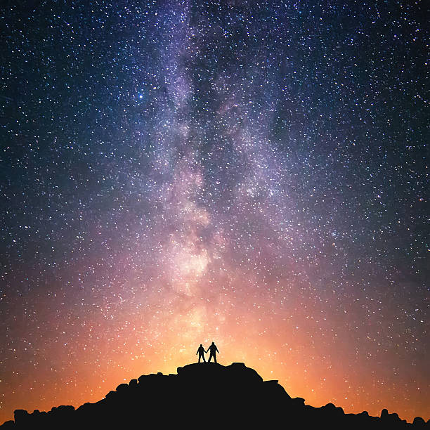 Universe for two Silhouttes of two people standing together holding hands against the Milky Way on the top of the hill.. annapurna conservation area photos stock pictures, royalty-free photos & images