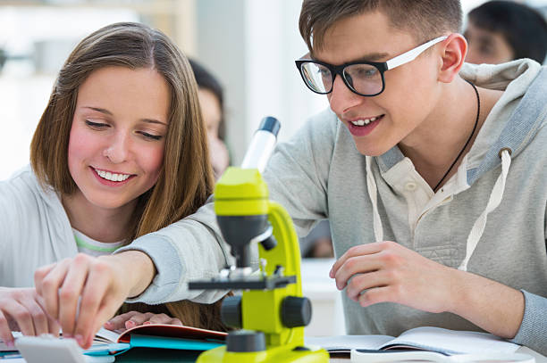 istock Girl and boy working together in biology class 586937762
