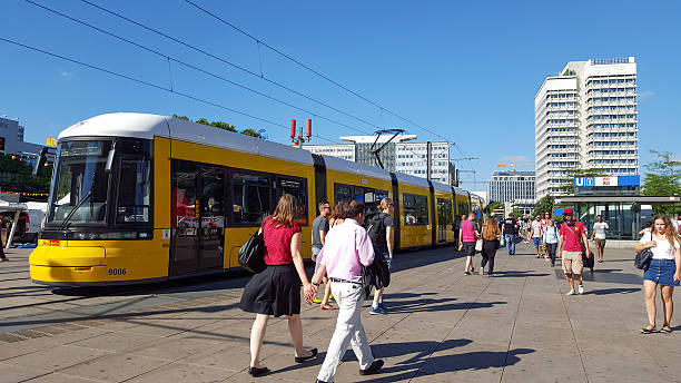 yellow tram in berlin alexanderplatz - clock station people berlin germany imagens e fotografias de stock