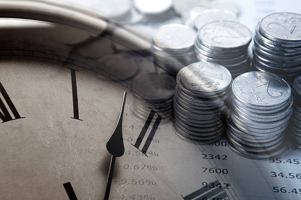 istock pile of coins with digits and clock face 586942650