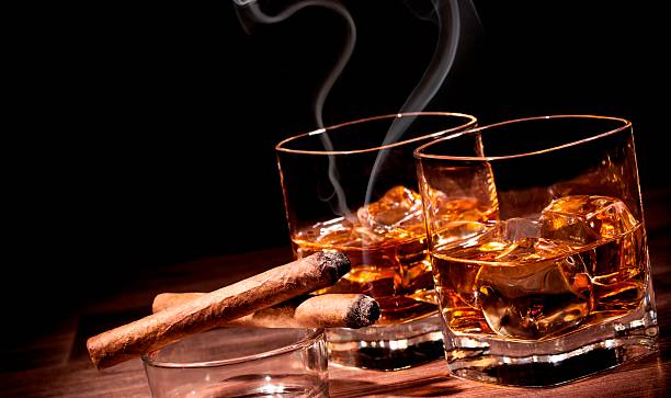 istock Two glasses of whiskey with ice and cigar 586944112