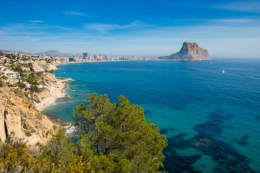 View along the Mediterranean Coast to Calpe and Penon de Ilfach, showing villas, cliffs and beaches and the main developments of Calpe town